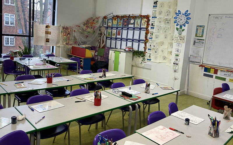 An empty classroom decorated with posters and drawings.
