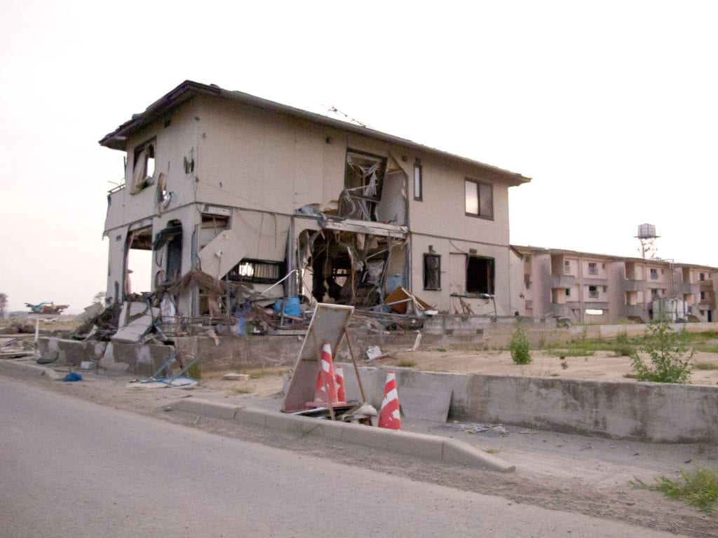 A damaged house on the side of a road