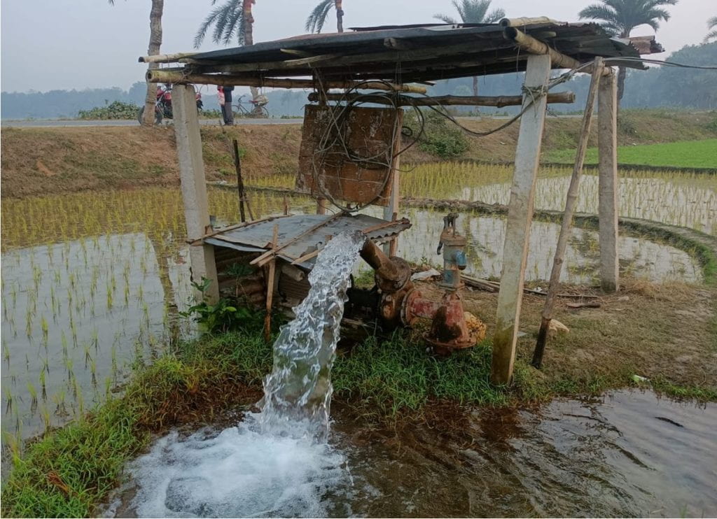 photograph of a water pump in wet agricultural land