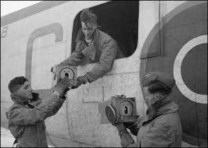 Crewmen of Consolidated Liberator of No. 53 Squadron RAF handling carriers containing homing pigeons