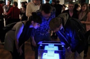 Examining a piece of DNA, the “Public BioBrick” at the 2012 “Right or Risk?” exhibition
