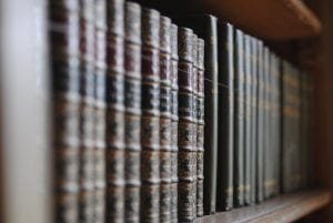 A close up of old leather-bound books on a shelf