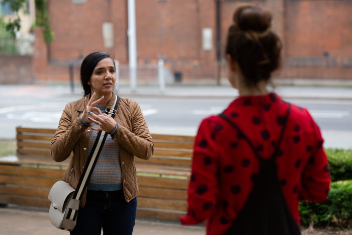 Artist Rubbena talks to her BSL interpreter outside St Paul's Way Trust School