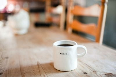 Image of a mug of coffee with 'Begin' written on it