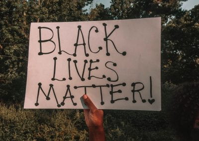 Hand holding sign saying' 'Black Lives Matter'