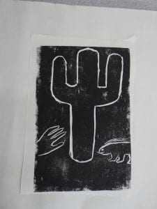 A black and white lino cut depicting a cactus, a hand reaching towards it and a porcupine looking on.