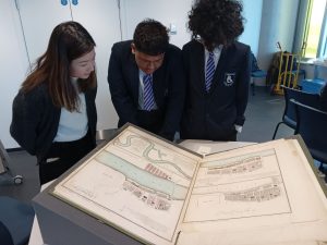 Photo of Kelmscott School students viewing a large folio-sized diagram of the River Thames, at UCL East.