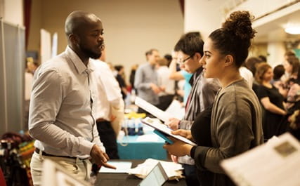 An Employer speaking to a student at the fair