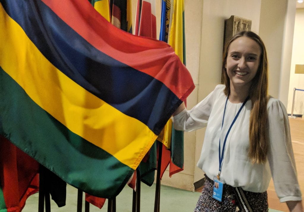 Student standing by a flag